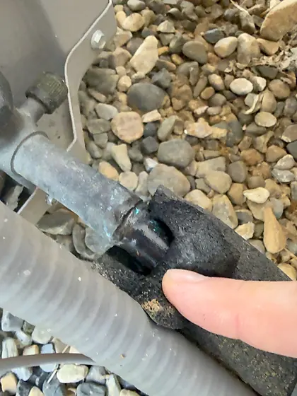 Localized gap in black refrigerant suction-line insulation near the Bryant condenser
