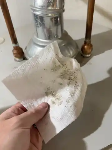 White paper towel after wiping around the water-heater top fittings