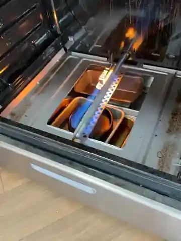Blue flame burning evenly along the Whirlpool oven bake burner after installing a new igniter